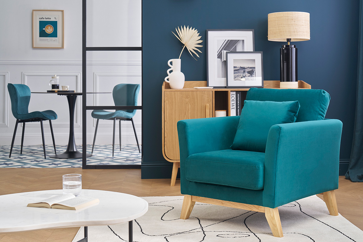 Fauteuil OSLO en velours bleu et bois clair dans un salon moderne.