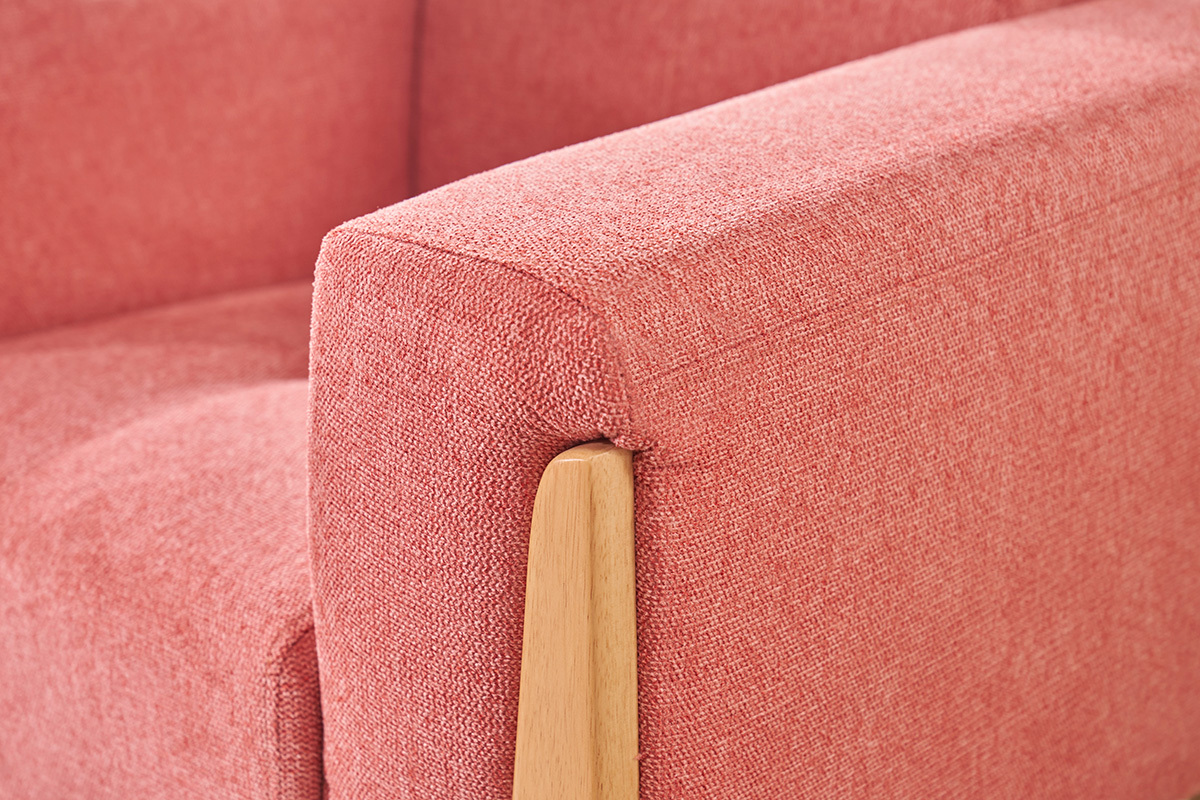 Accoudoir du fauteuil scandinave en tissu terracotta avec bois clair.