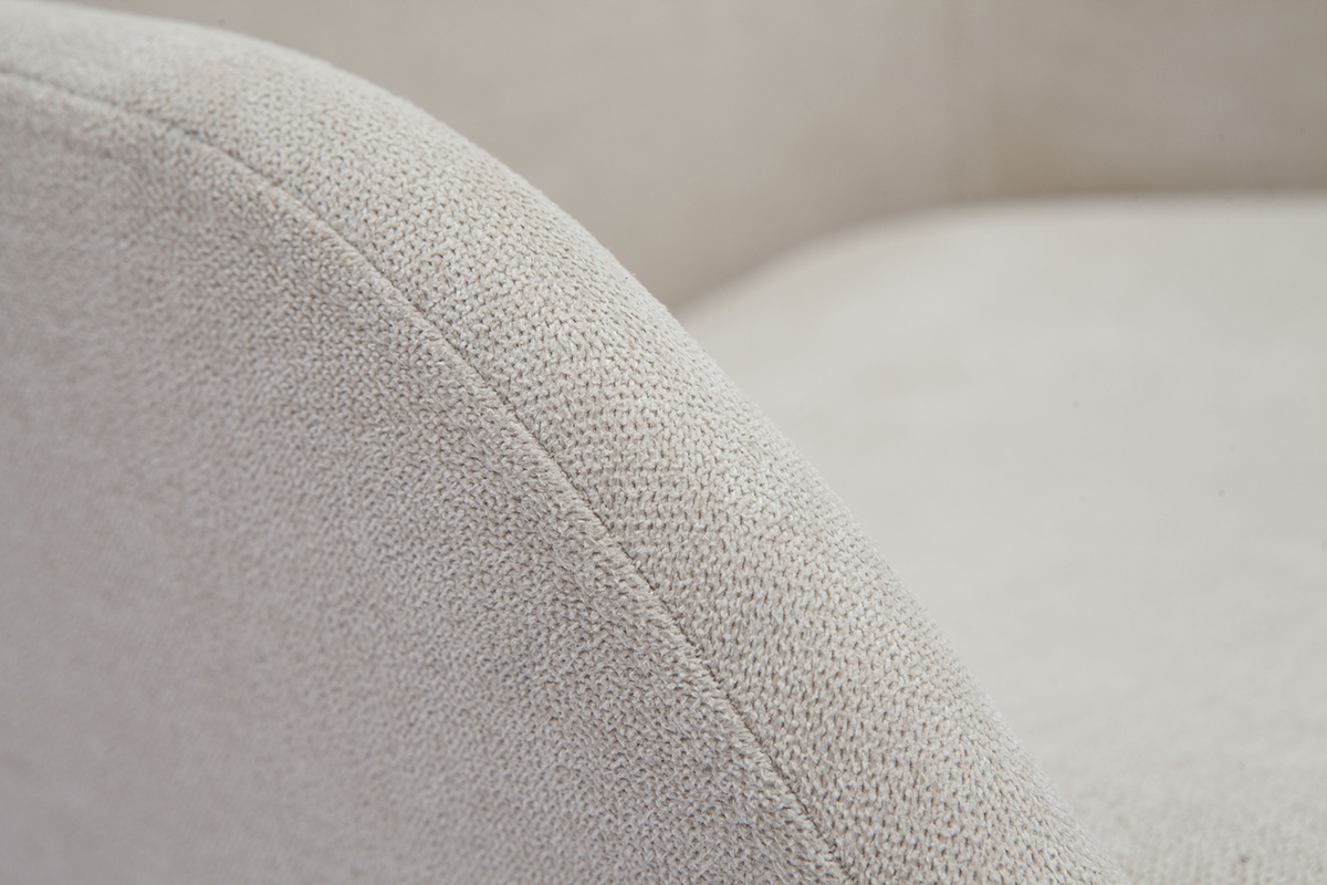 Gros plan sur tissu effet velours beige d'un fauteuil scandinave.