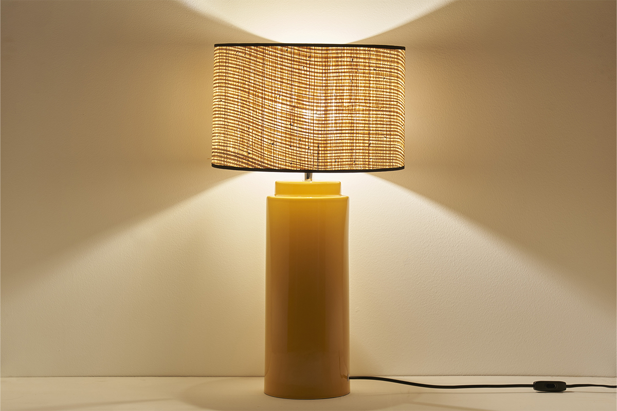 Lampe en c�ramique �maill�e jaune avec abat-jour en raphia naturel, vue de face.