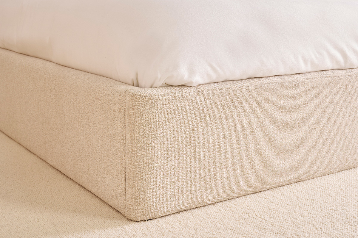 Vue rapproch�e d'un lit coffre beige en tissu textur� avec matelas.