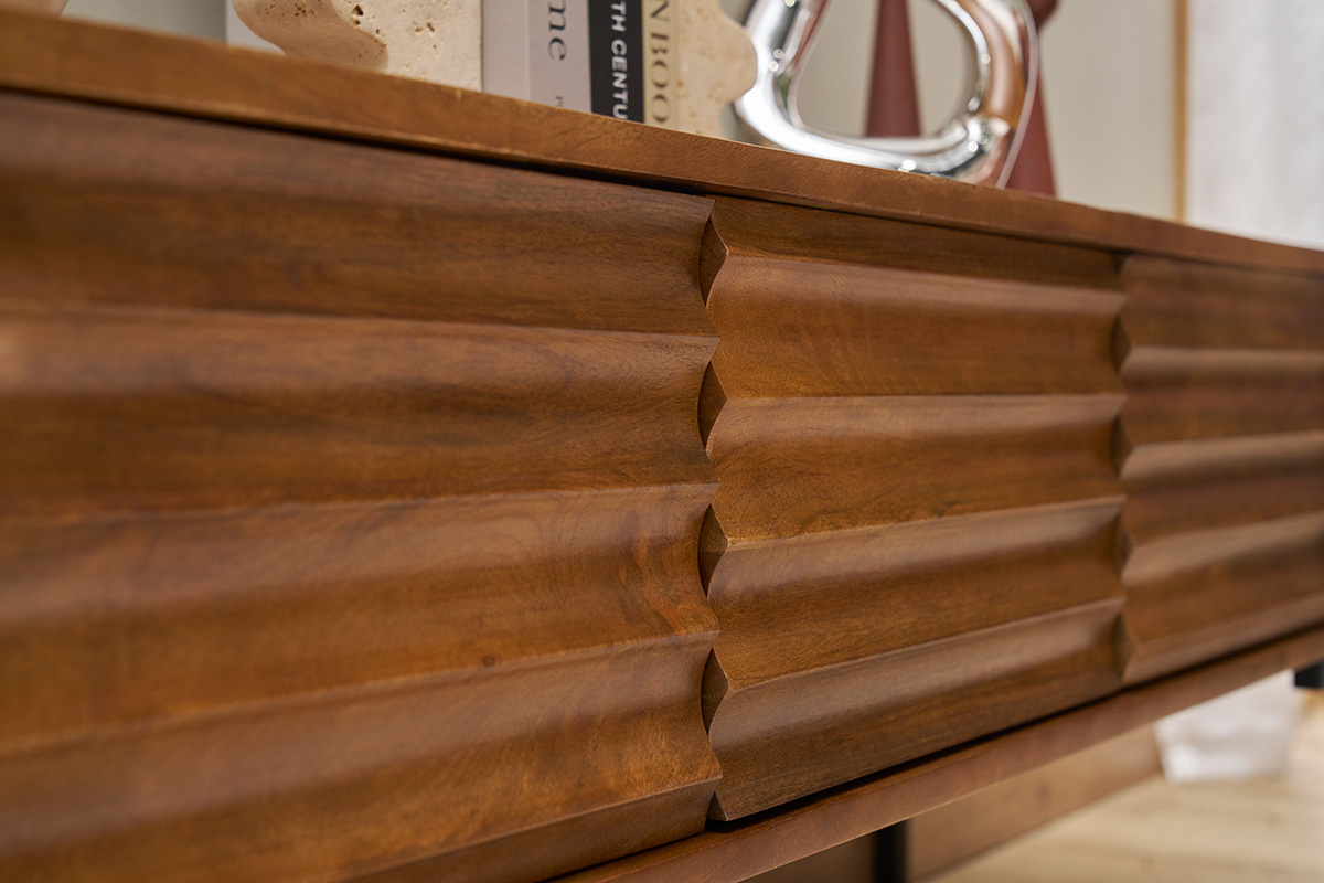 Gros plan sur le meuble TV ONDA en bois de manguier massif avec motifs sculpt�s.