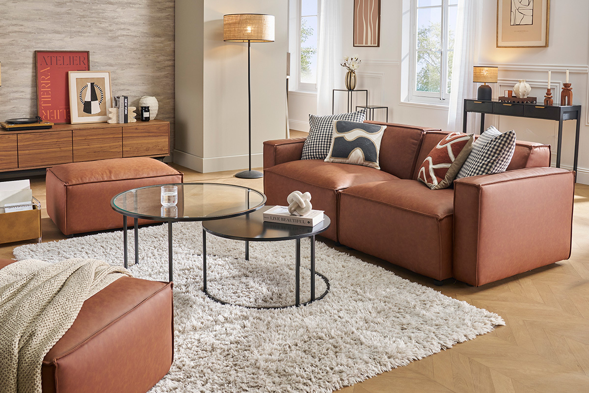 Salon moderne avec canap� modulable en cuir marron SPLIT, pouf et tables basses rondes.