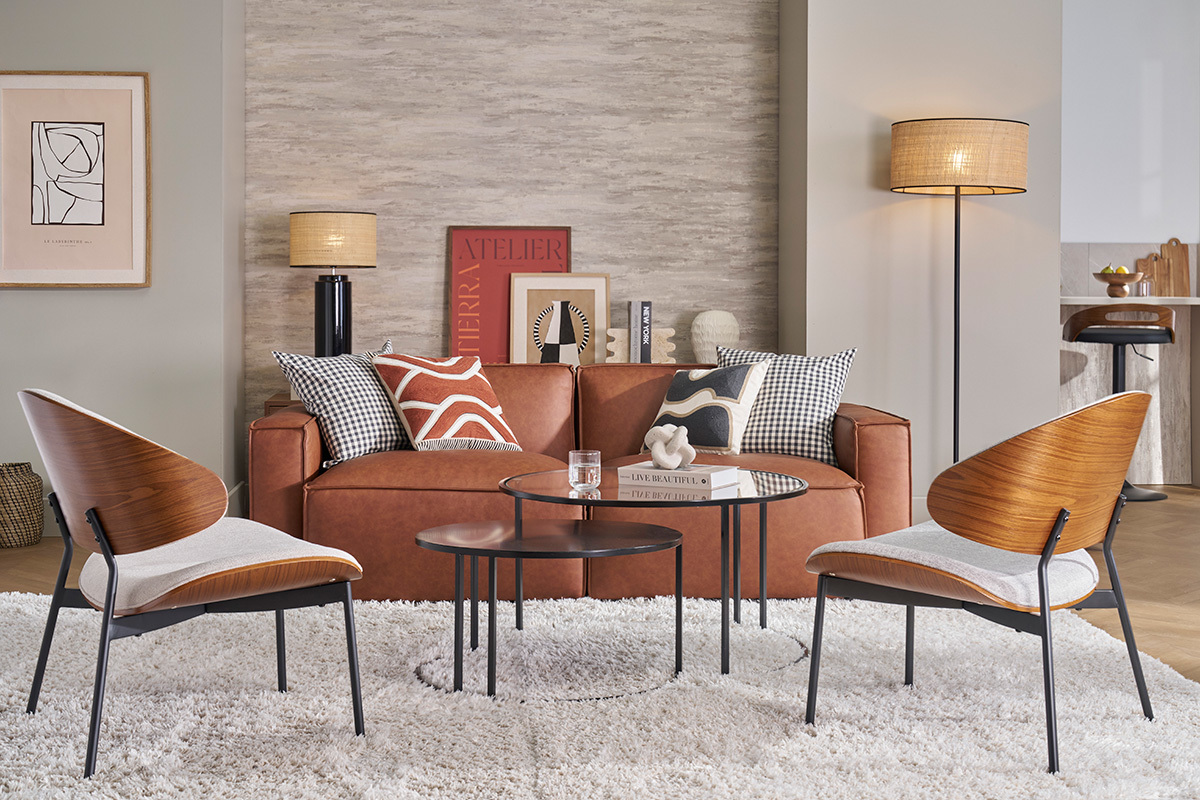 Canap� en cuir marron avec coussins, tables basses et deux chaises dans un salon moderne.