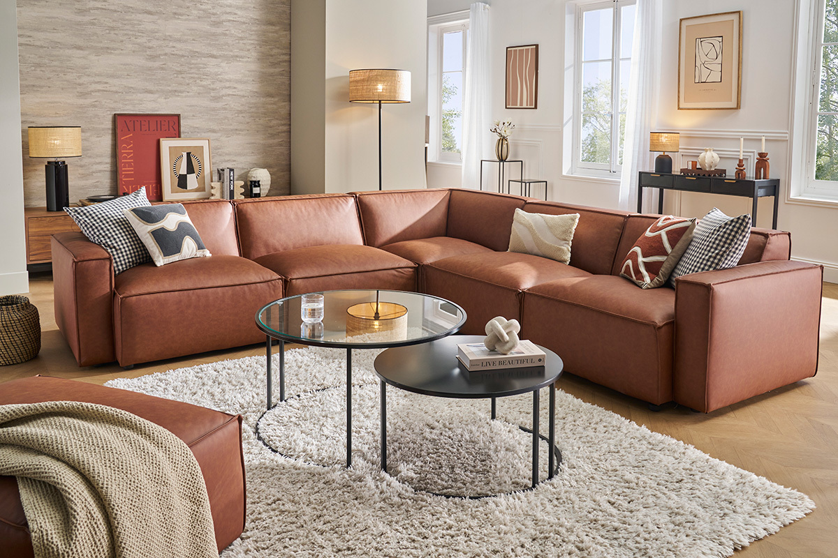 Salon avec canap� en cuir marron et tables basses sur un tapis blanc.