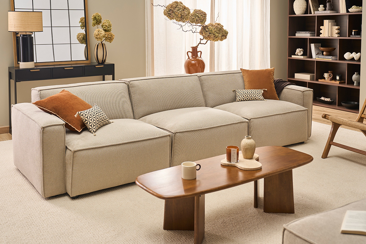 Canap� beige en tissu chenille dans un salon moderne avec table basse en bois et �tag�res.