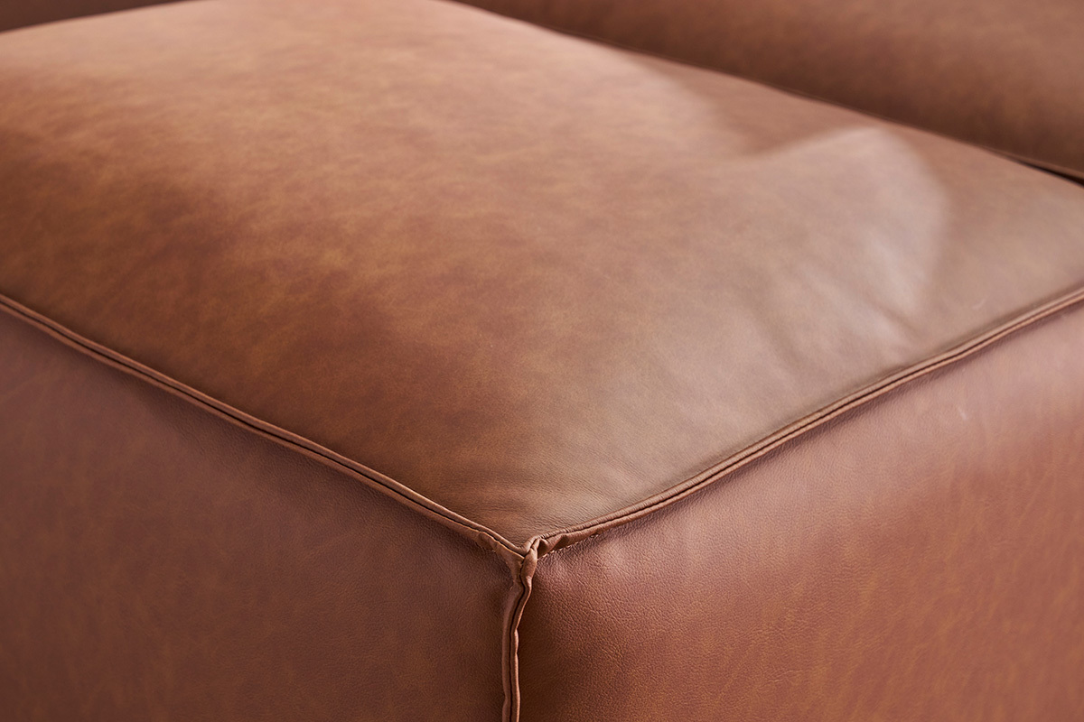 Vue rapproch�e d'un pouf en cuir marron avec coutures visibles.