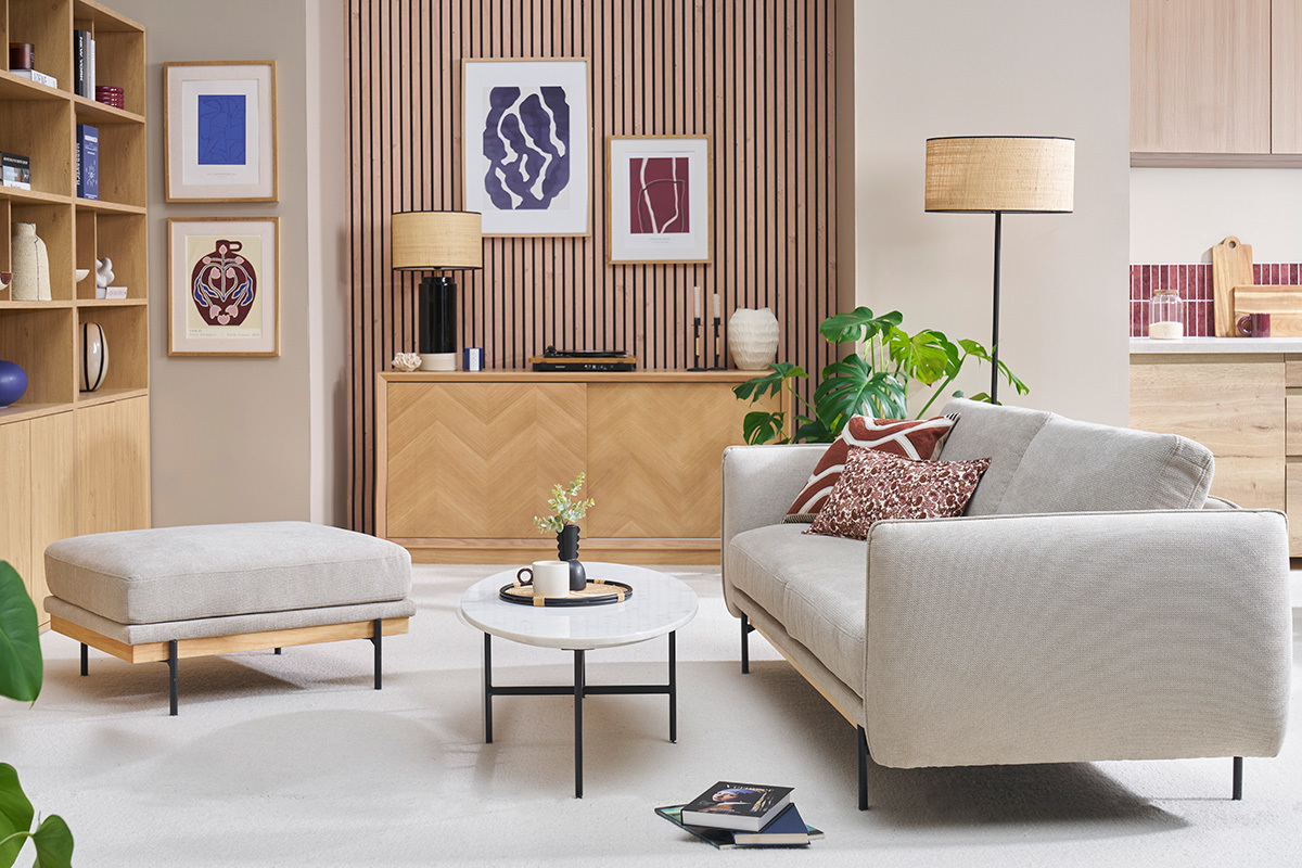 Salon avec pouf repose-pieds en tissu chenille beige, table basse ronde et canap�.