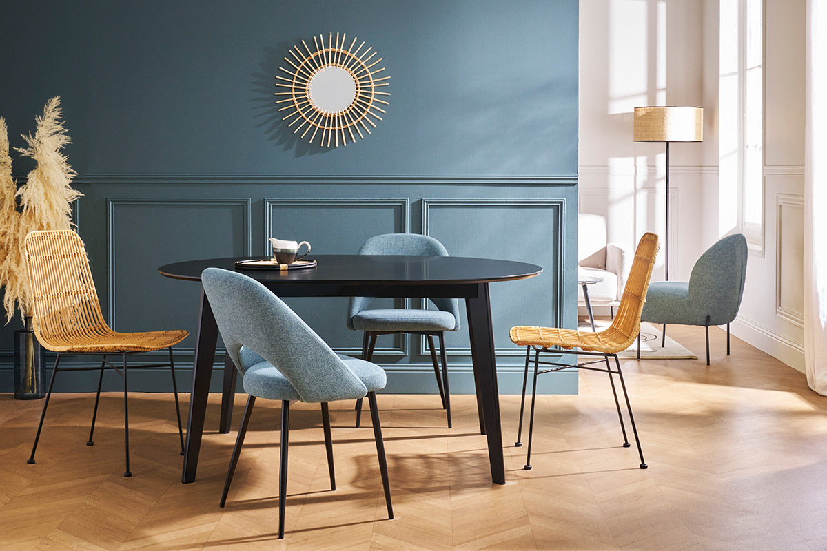 Table � manger ronde noire LEENA avec chaises design dans une salle � manger, vue de 3/4.