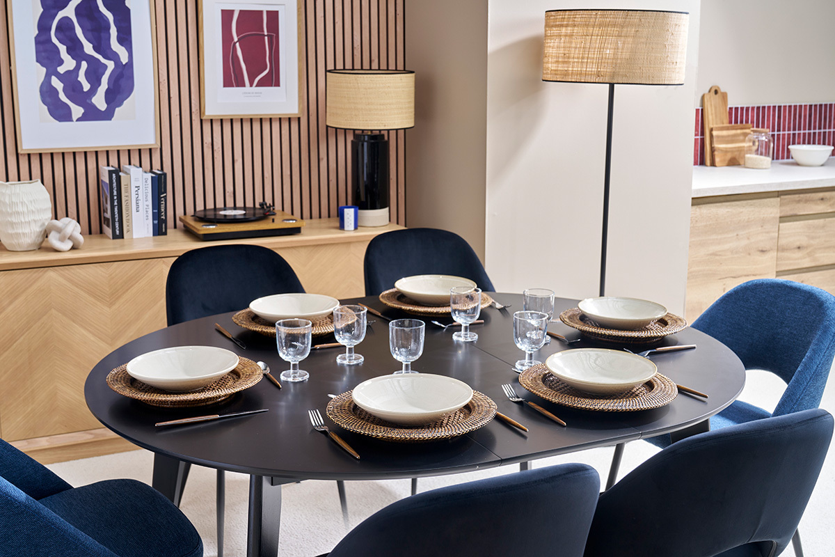 Table ronde extensible noire LEENA dress�e pour 6, vue du dessus, entour�e de chaises bleues.