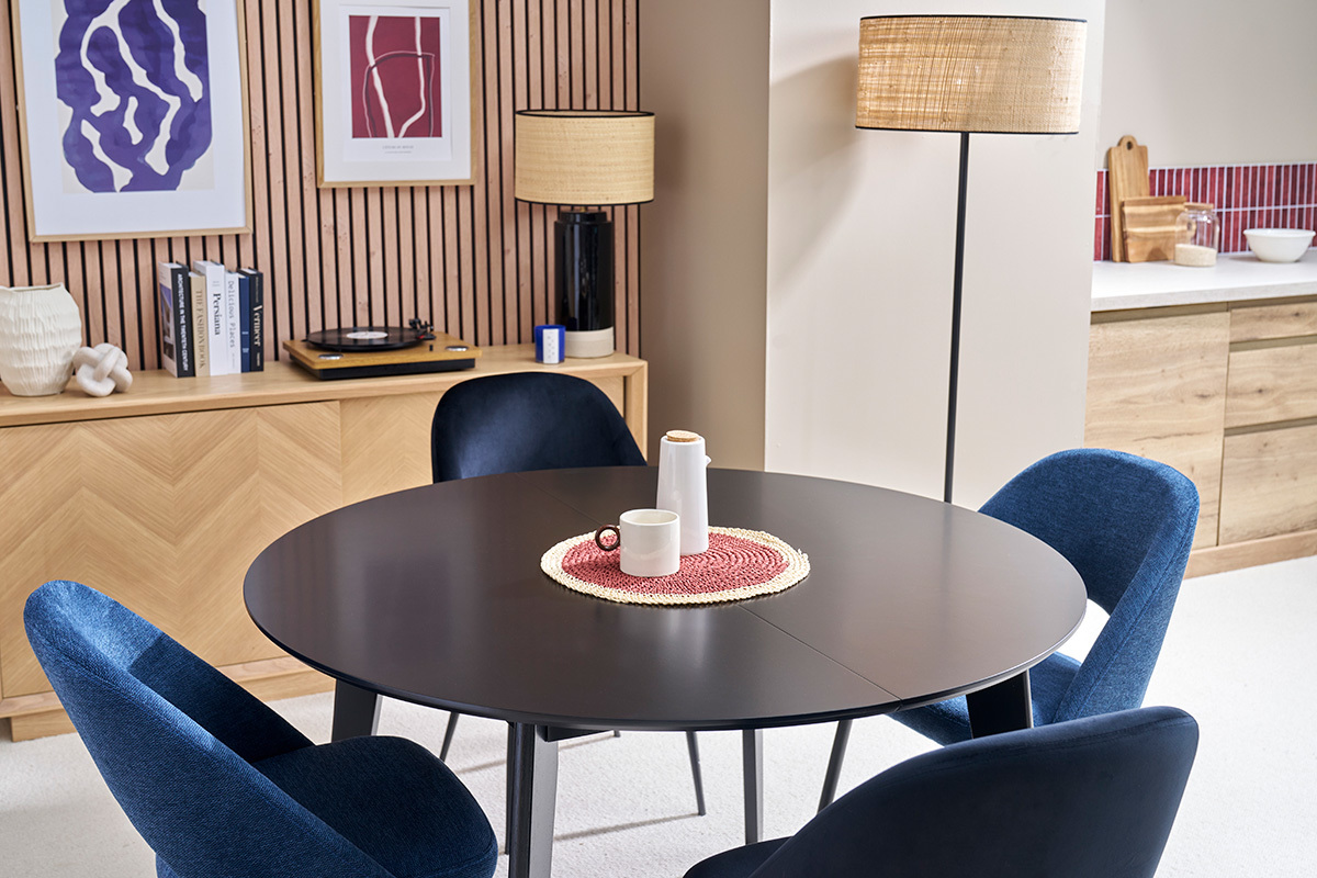 Table � manger ronde extensible noire LEENA avec chaises bleues.