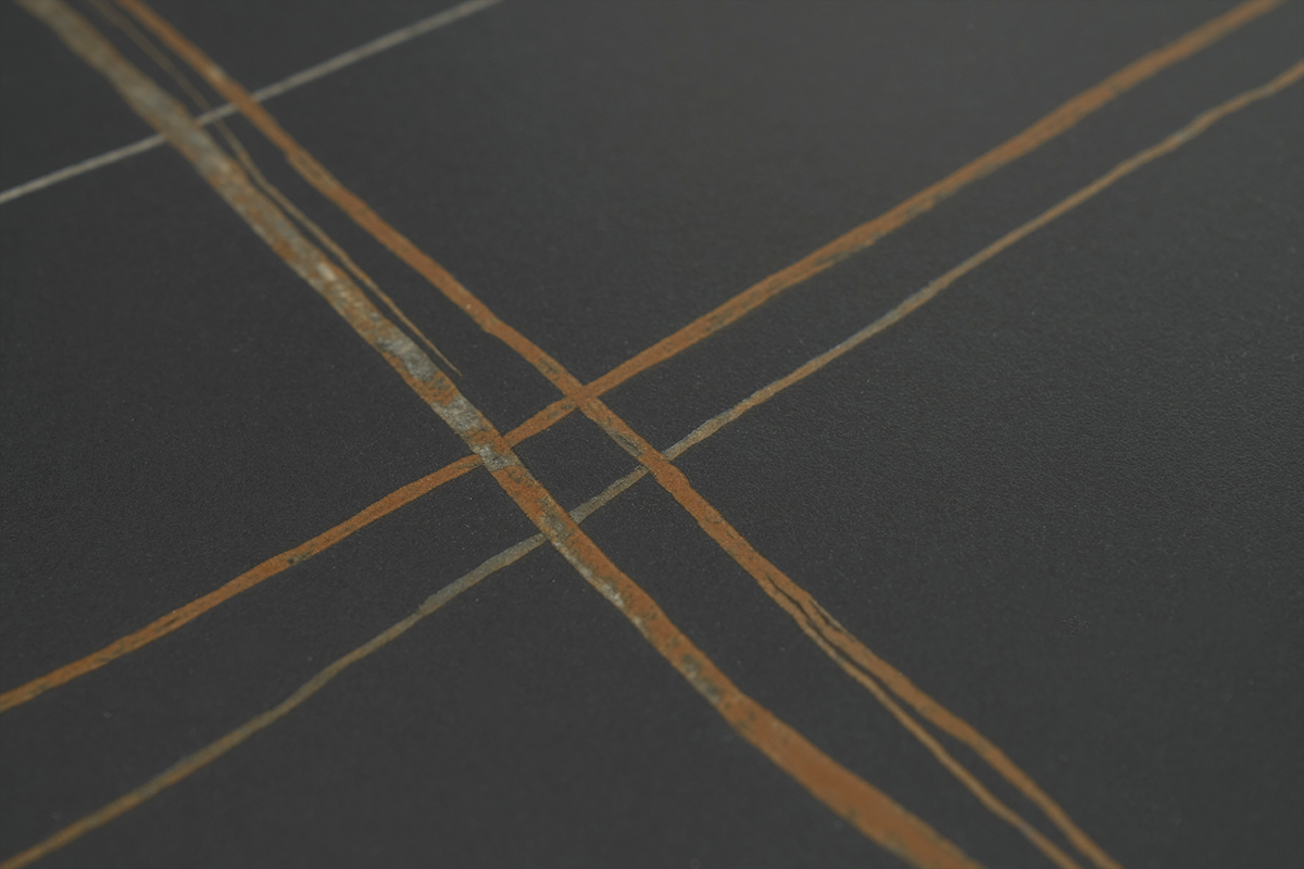 D�tail du plateau en c�ramique noire avec motifs ligneaires orang�s de la table MALOU.