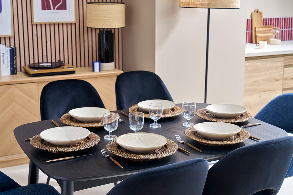 Table � manger noire NORDECO dress�e avec assiettes et verres, vue de dessus.