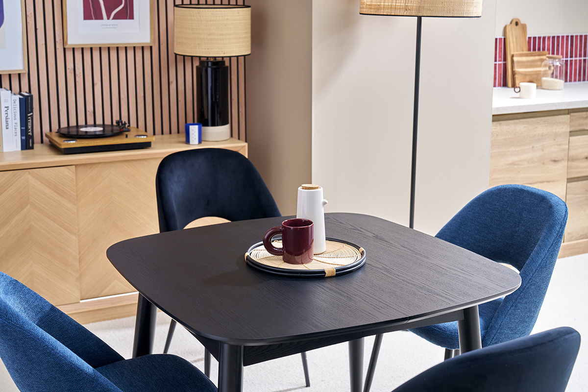 Table � manger noire extensible NORDECO avec chaises bleues, vue d'angle.