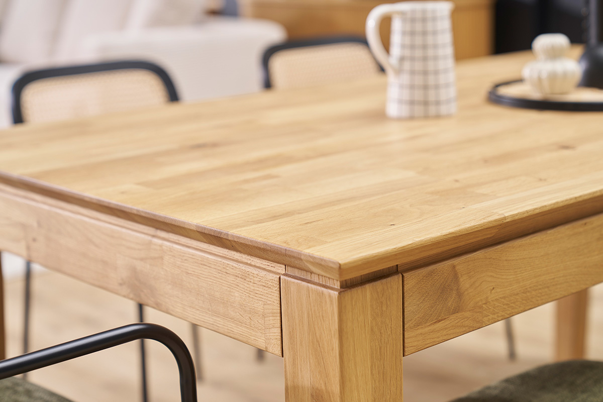 Table � manger extensible en bois clair, vue de c�t� avec objets pos�s dessus.