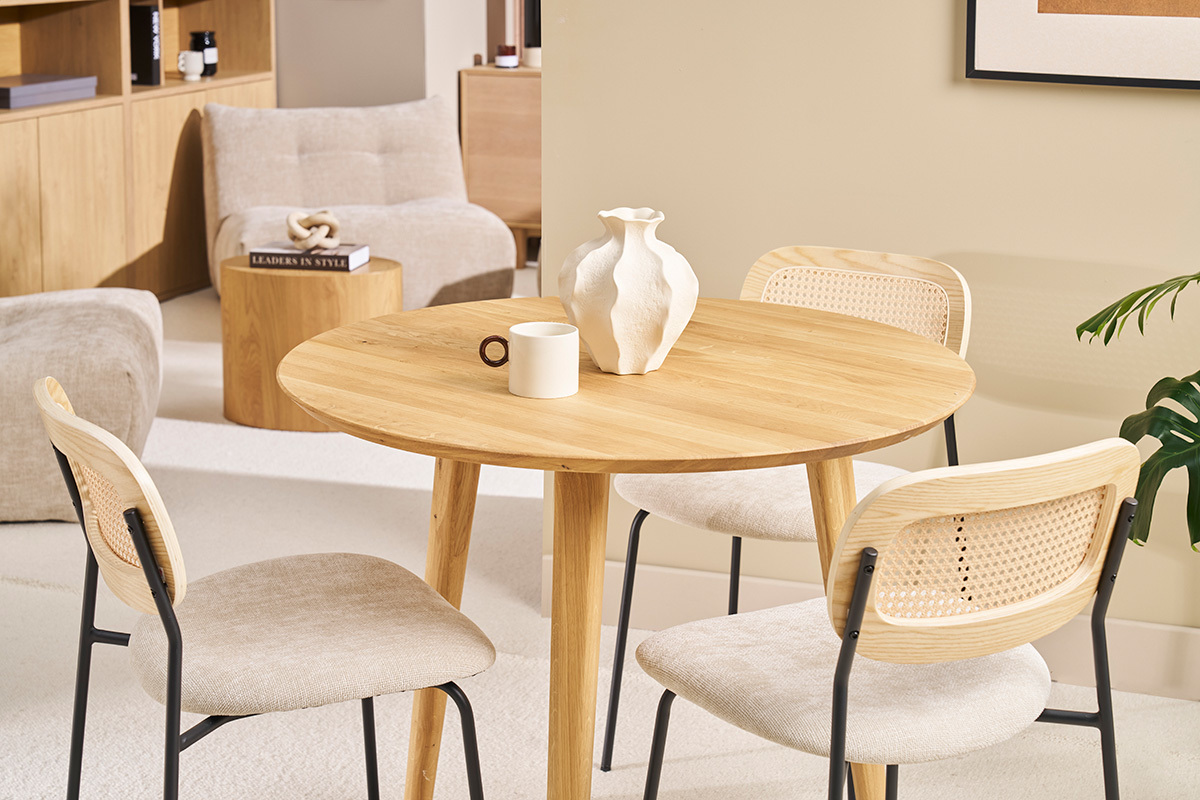 Table ronde en bois clair avec chaises, vue d'ensemble salle � manger.