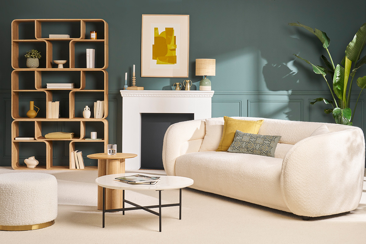 Salon avec table basse en marbre blanc et m�tal noir, canap� cr�me et �tag�re en bois.