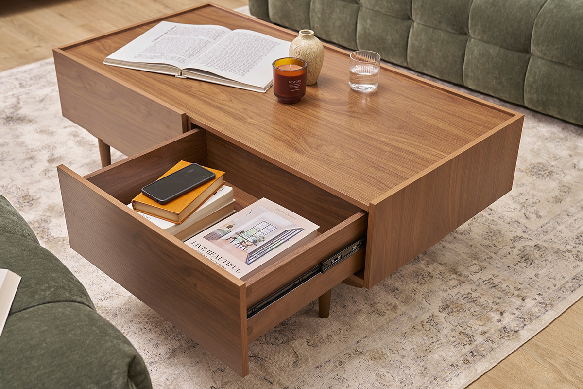 Table basse rectangulaire SANAA avec tiroirs ouverts, livres et objets, vue de dessus.