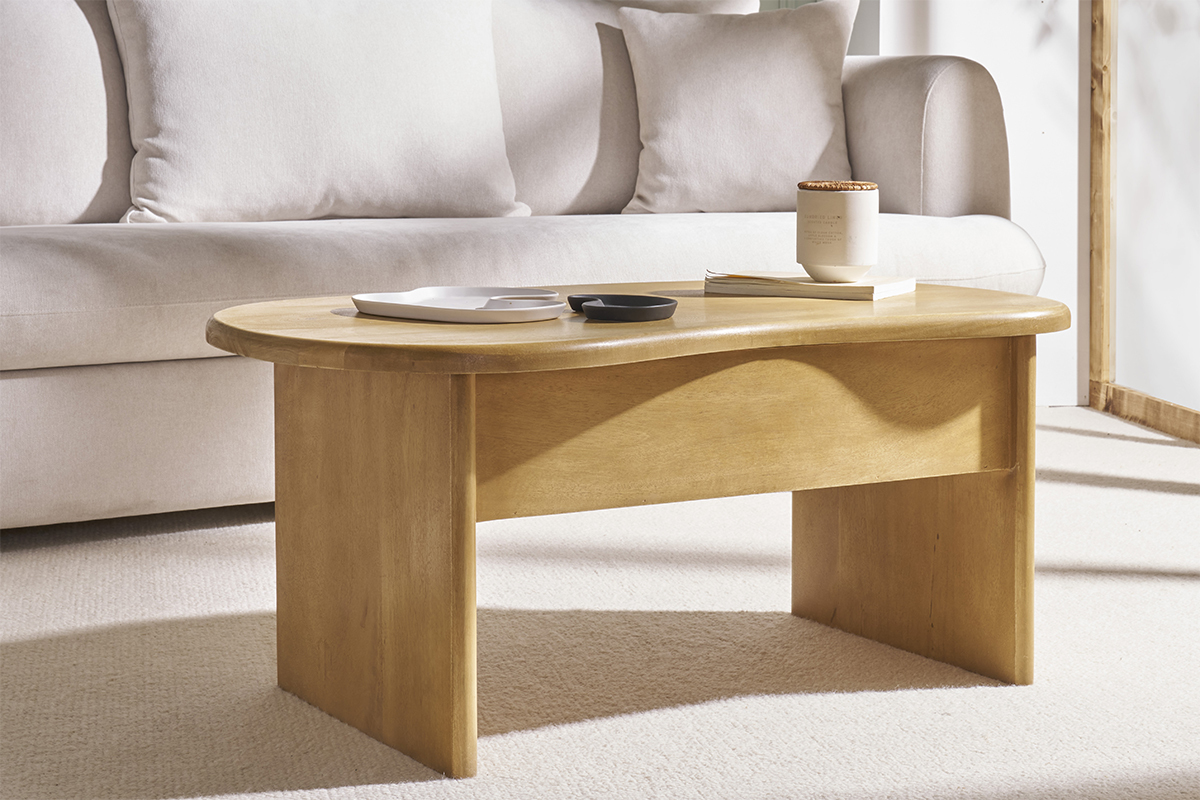 Table basse relevable en bois de manguier KOKOA, vue de face, avec objets dessus, devant un canap�.
