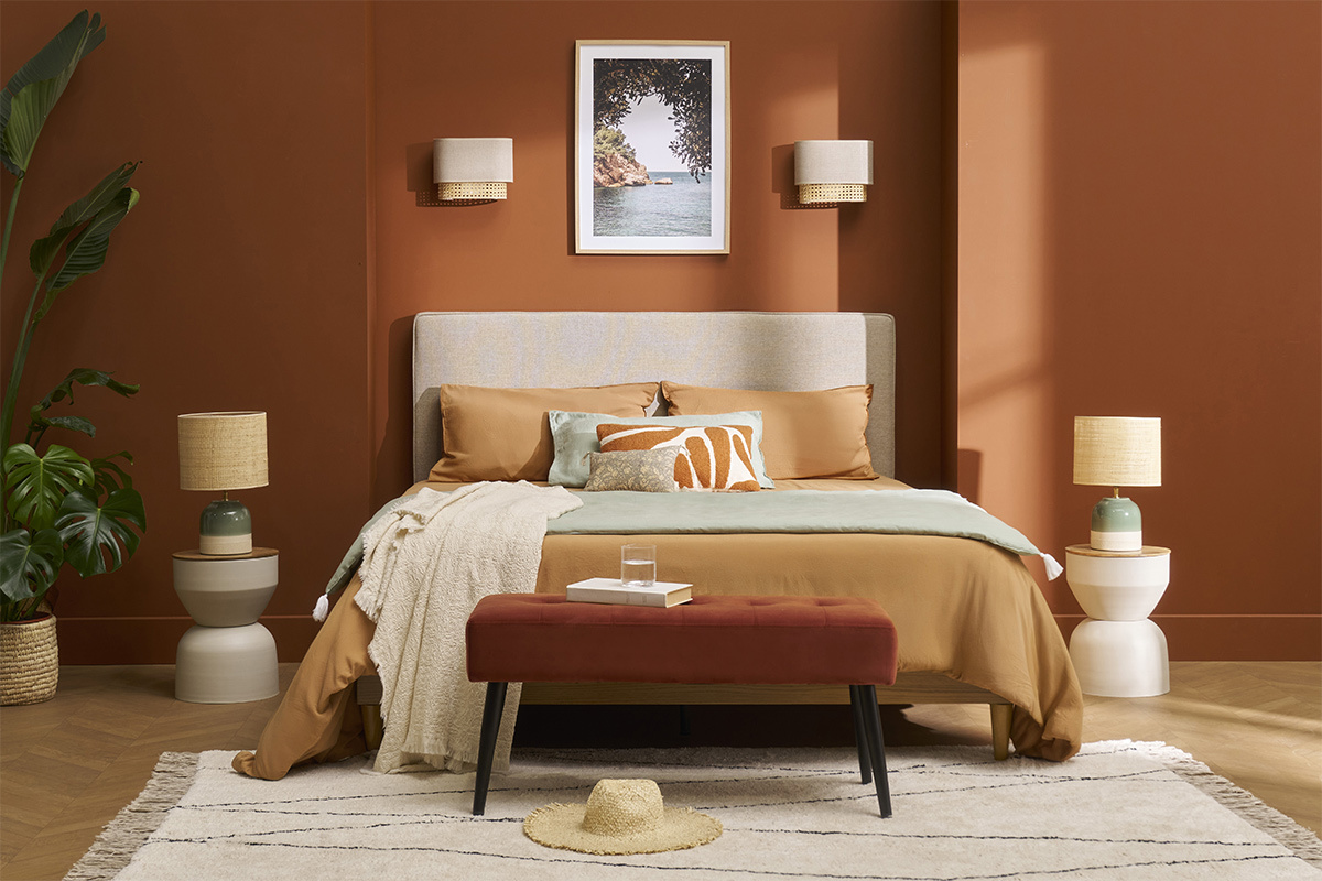 Table d'appoint ronde YOYO en m�tal gr�ge et bois pr�s d'un lit dans une chambre.