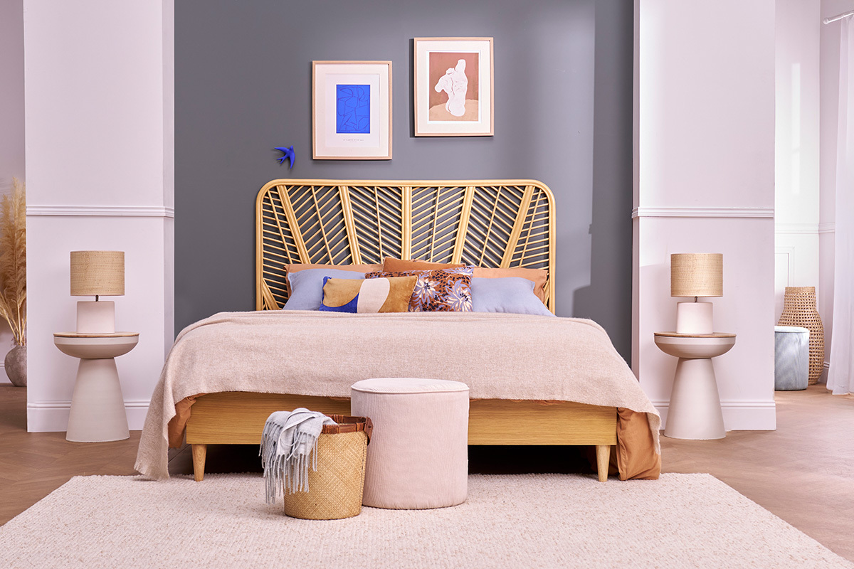 Chambre avec lit, t�te de lit en rotin, et tables d'appoint TAM en m�tal et bois de chaque c�t�.