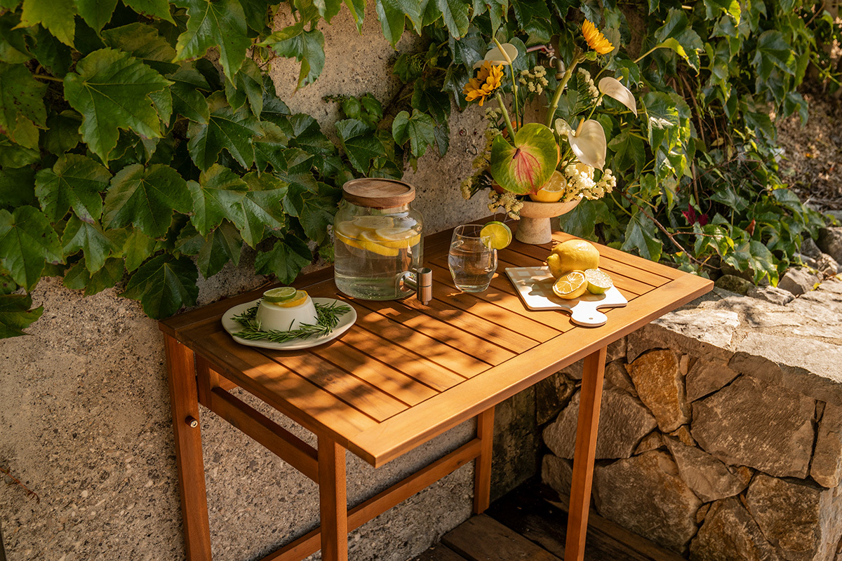 Table de balcon pliante en bois massif avec d�corations, vue de dessus, entour�e de plantes.