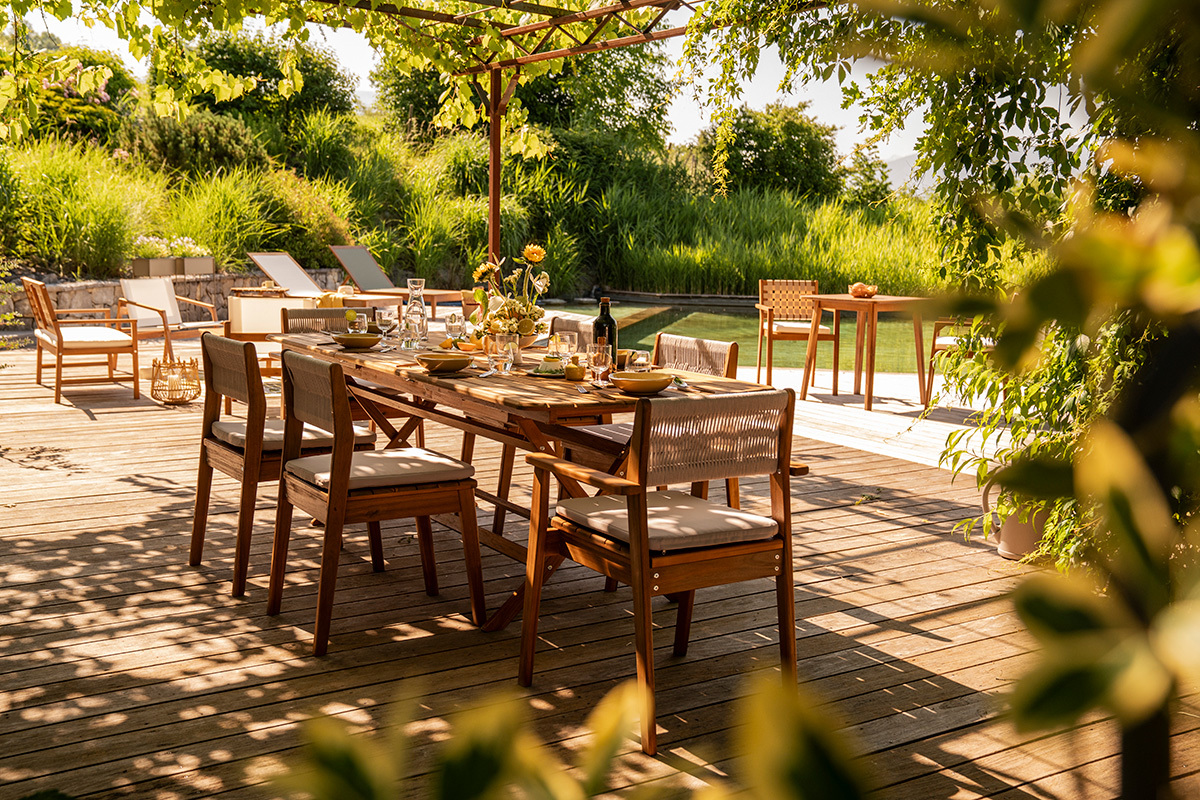 Table de jardin extensible en bois massif avec chaises, vue partielle sur une terrasse ensoleill�e