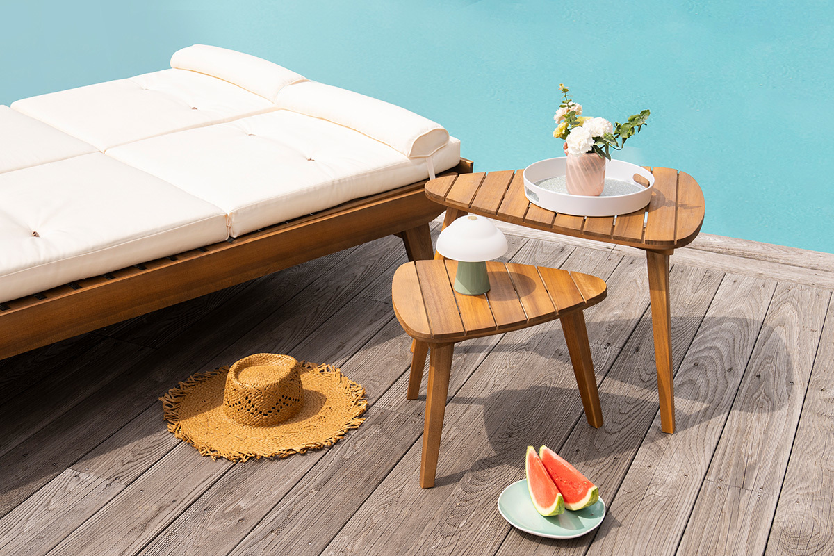 Tables basses gigognes en bois massif ELQUI pr�s d'une chaise de jardin, avec des accessoires d'ext�rieur.