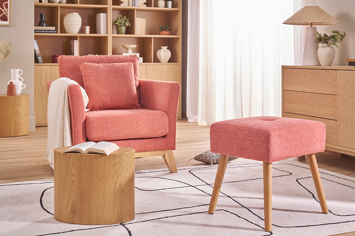 Tabouret terracotta et bois clair dans un salon cosy avec fauteuil et meubles en bois.