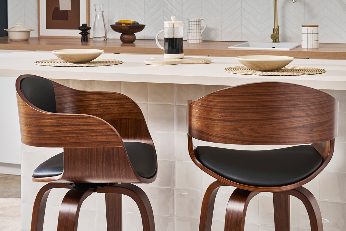Deux tabourets de bar en bois fonc� et noir, design, plac�s devant un comptoir de cuisine.