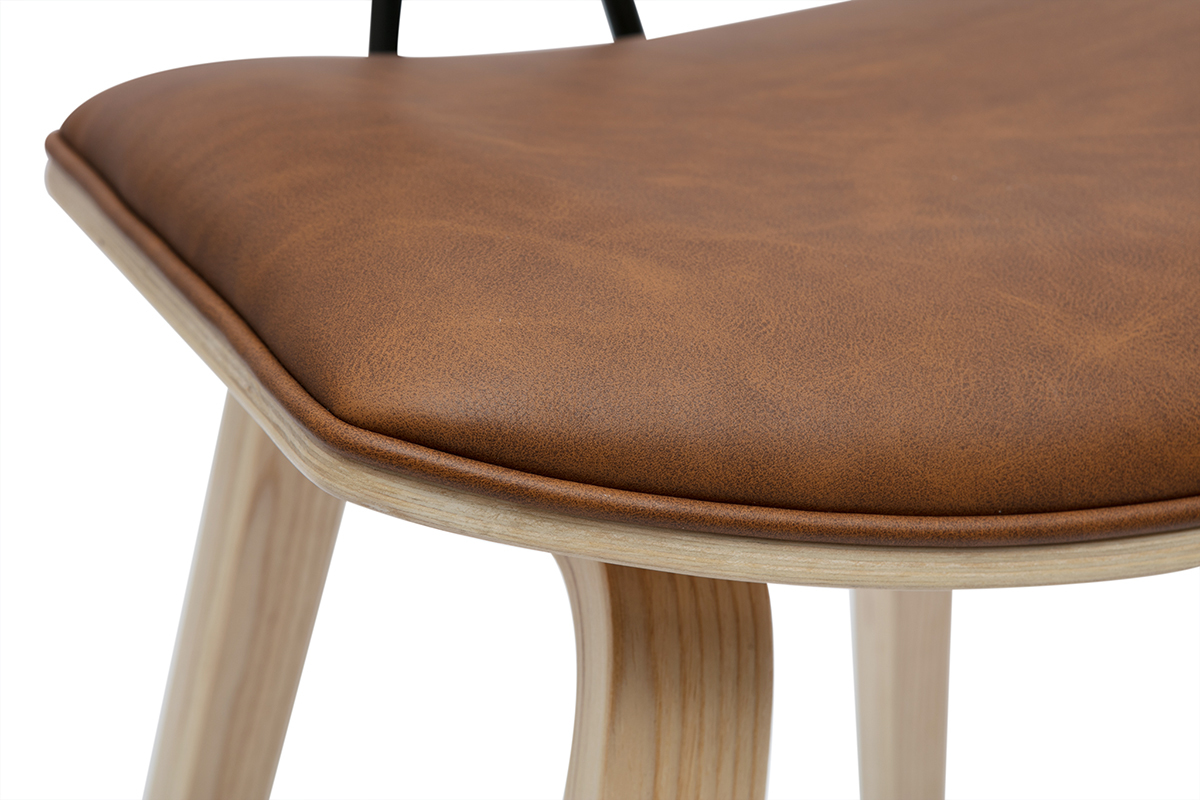 Gros plan sur l'assise marron d'un tabouret de bar en bois clair.