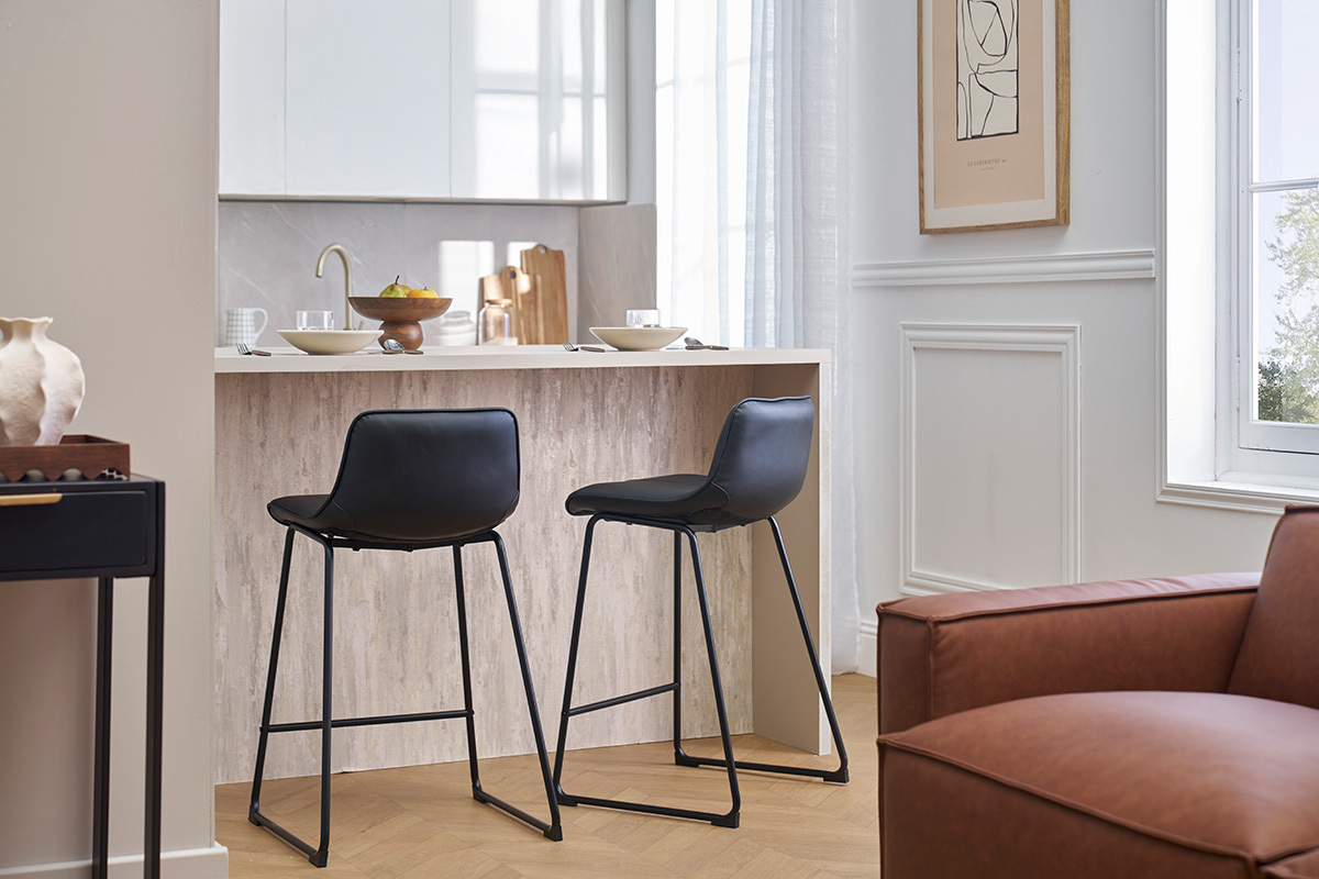 Deux tabourets de bar noirs et m�tal H65 cm devant un comptoir de cuisine.