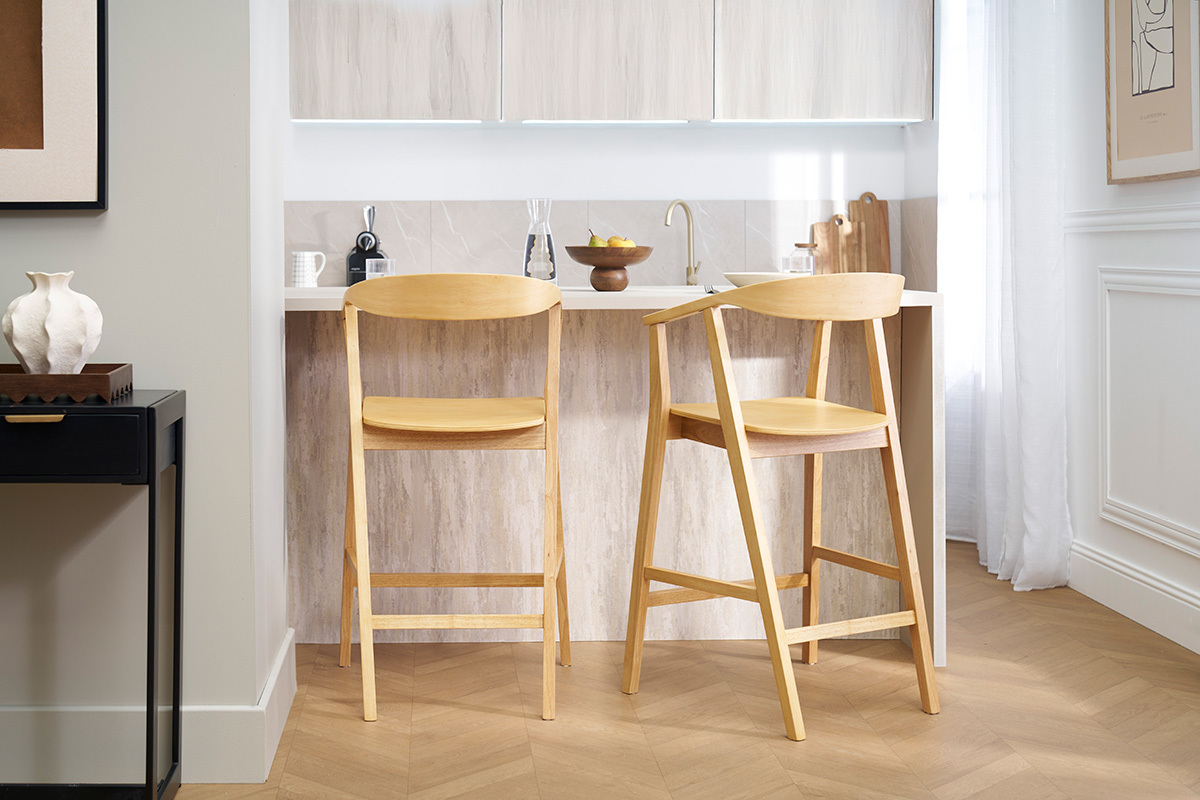 Tabourets de bar scandinaves en bois clair devant un �lot de cuisine.