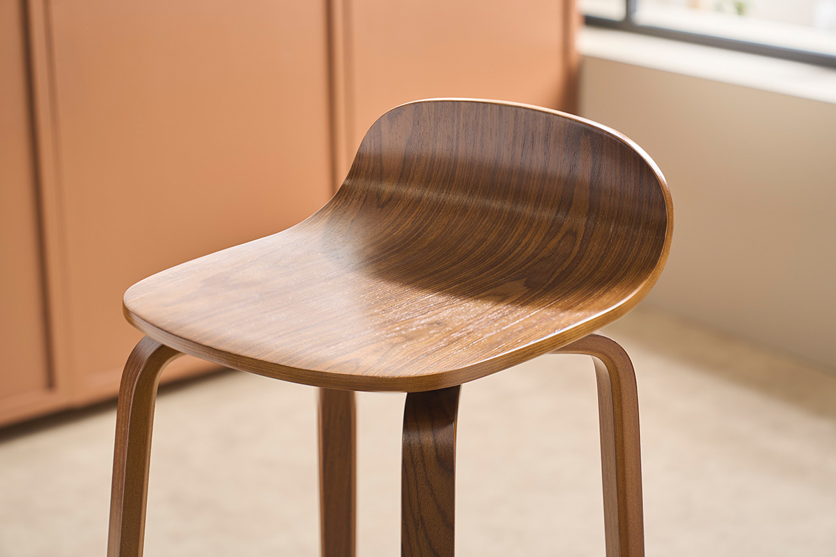 Vue rapproch�e d'un tabouret de bar vintage en noyer, assise large et dossier incurv�.