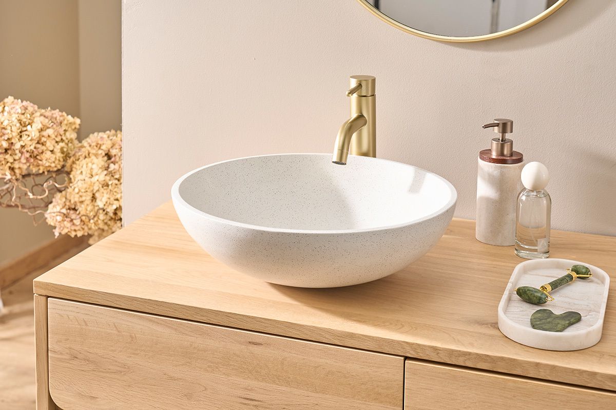 Vasque ronde en terrazzo gris LAORA sur meuble en bois, vue de trois quarts.